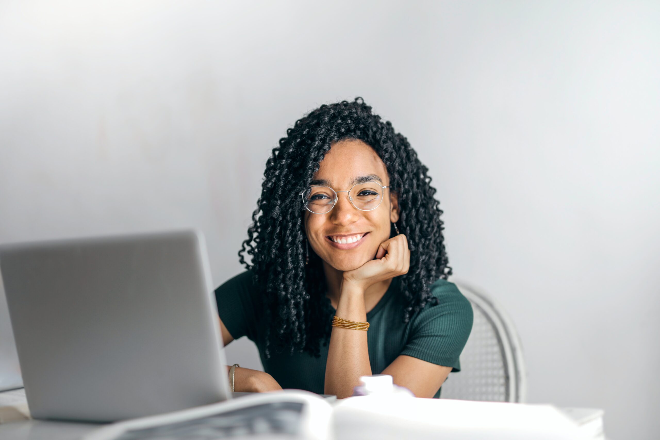 Happy Ethnic Woman sitting at the table TalentSmartEQ’s Assessment - Emotional Intelligence Appraisal Test