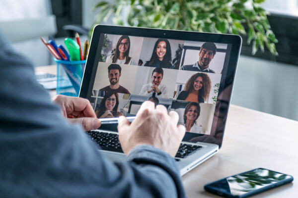 Male employee speaking on video call with diverse colleagues on online briefing with laptop at home. Mastering EQ Level 1 Certification Program